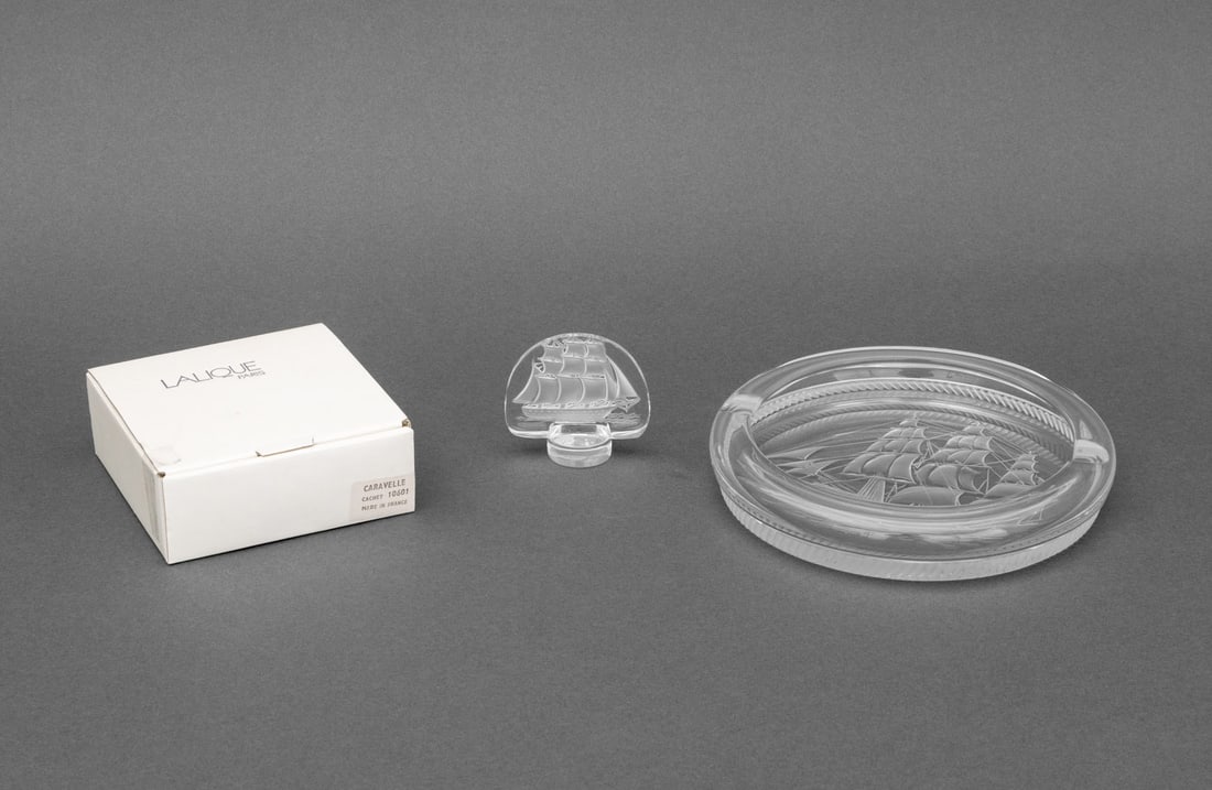 Lalique Crystal Sailing Ship Motif Articles, 2: Two Lalique Crystal Sailing Ship Motif Articles, both marked "Lalique France" and comprising: a "Caravelle" pattern paperweight with original box and a "Clyba" pattern cendrier. Larger: 7" Diameter x
