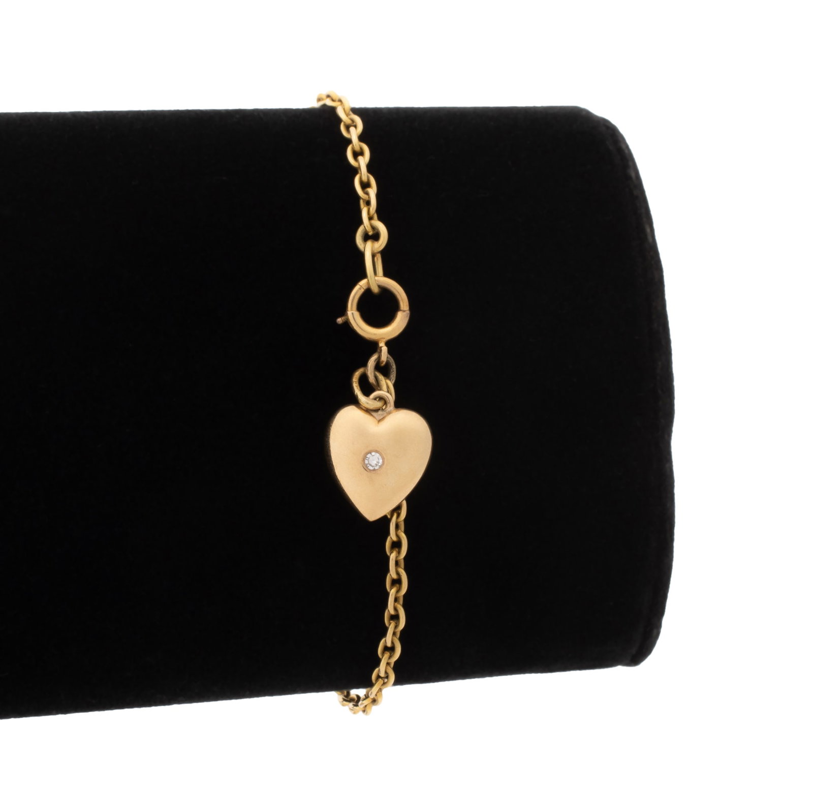Diamond and Yellow Gold Heart Charm Bracelet: 14K Yellow Gold and Diamond Heart Charm Bracelet, crafted with oval link chain, featuring one fixed heart charm adorned with one flush set round faceted diamond weighing approx. 0.02 carat, joined wit