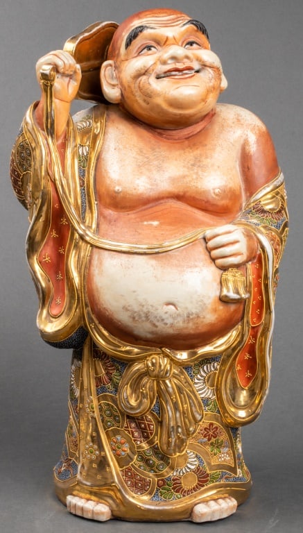 Japanese Satsuma Porcelain Buddha Sculpture: Japanese Satsuma Porcelain Standing Buddha Sculpture, standing figure holding fan, with elaborate enamel-accented drapery, marked to underside. 18" H x 10" W x 7.5" D. Provenance: From a Rye, New York