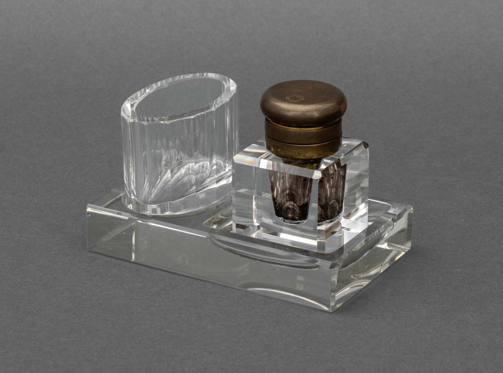 Montblanc Brass and Crystal Inkwell: Montblanc Brass and Crystal Inkwell, lid marked "Montblanc" and with logo. Overall: 3.25" H x 4.75" W x 3" D. Provenance: From a Tribeca Estate. Keywords: Luxury goods, Desk accessories, Desk set, Wri