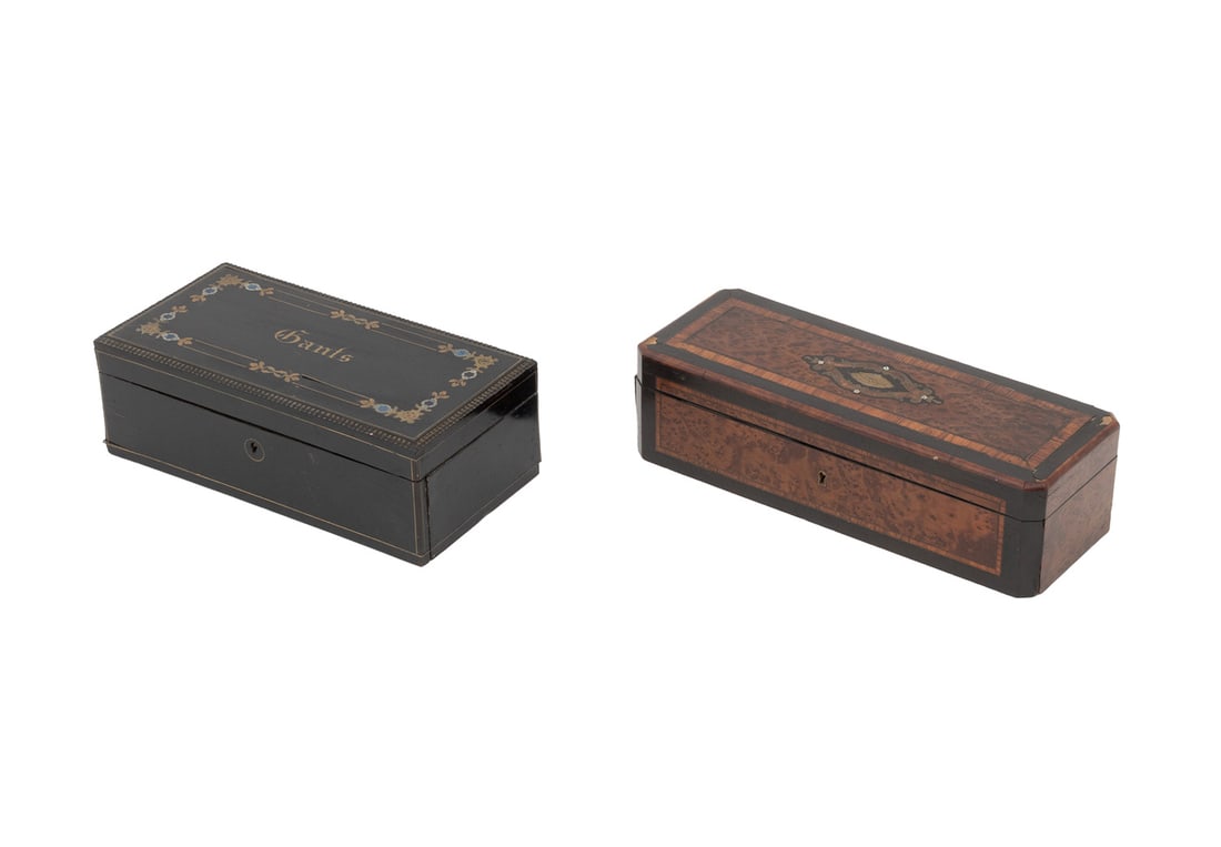French Gloves Boxes, 2: Two French Gloves Boxes, comprising: burl walnut with ebonized and mother-of-pearl inlay to the lid, and ebonized wood box with brass string, floral motif, and "Gants" inlay to the lid. Larger: 3.5"