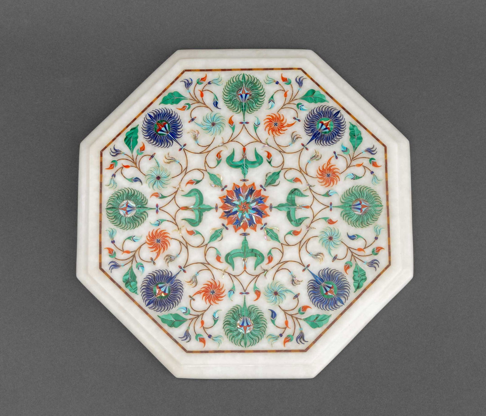 Indian Semi-Precious Stone Inlaid Octagonal Plaque: Indian Semi-Precious Stone Inlaid White Alabaster Octagonal Plaque, depicting a floral medallion with inlay of malachite, lapis lazuli, abalone, turquoise, and coral. 11.75" L x 12.75" W x 1" D.