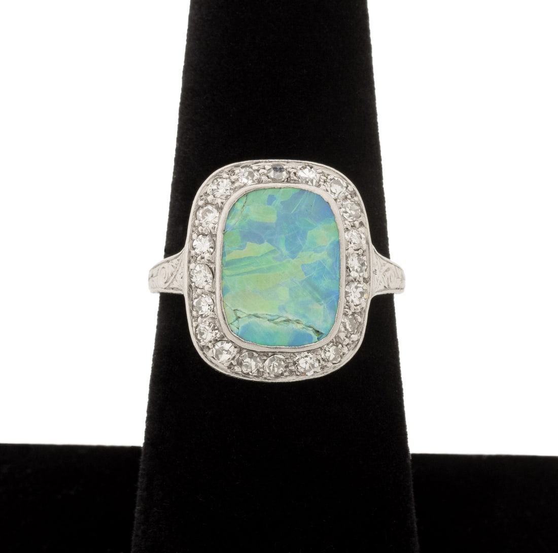 Antique Opal, Diamond, and Platinum Ring: Antique Platinum, Opal, and Diamond Ring, adorned with one centered bezel set opal cabochon weighing approx. 4.25 carats, further adorned with twenty pave set round faceted diamonds weighing a total o
