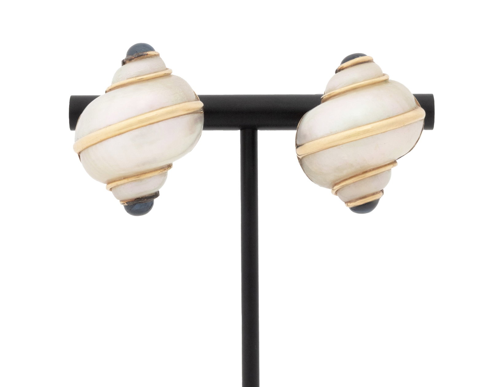 Mazza Gold and Sapphire Mounted Shell Earrings: Pair of Mazza 14K Yellow Gold and Sapphire Mounted Mother-of-Pearl Shell Earrings, designed as shell shaped MOP adorned with four bezel set blue sapphire round cabochons weighing a total of approx. 3.