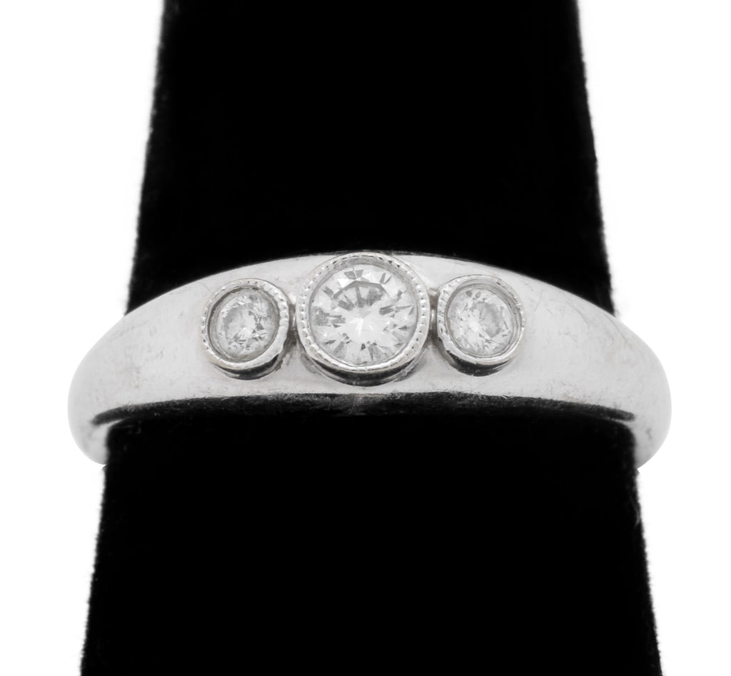 Three-Stone Diamond and White Gold Band Ring: 14K White Gold and Diamond Three Stone Ring, featuring 3 bezel set round brilliant cut diamonds, weighing a total of approx. 0.30 carat, marked: "14K S". Measuring approx. US size 8 1/2, 3/16" across 