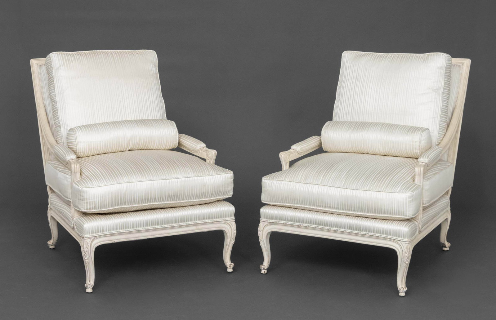 Louis XVI Style White Painted Fauteuils, Pair: Pair of Louis XVI Style White Painted Wood Fauteuils, with silk-blend white upholstered cushions and lumbar pillows. 35.5" H x 28" W x 32" D; seat: 18" H. Provenance: From a 500 Park Avenue Estate.