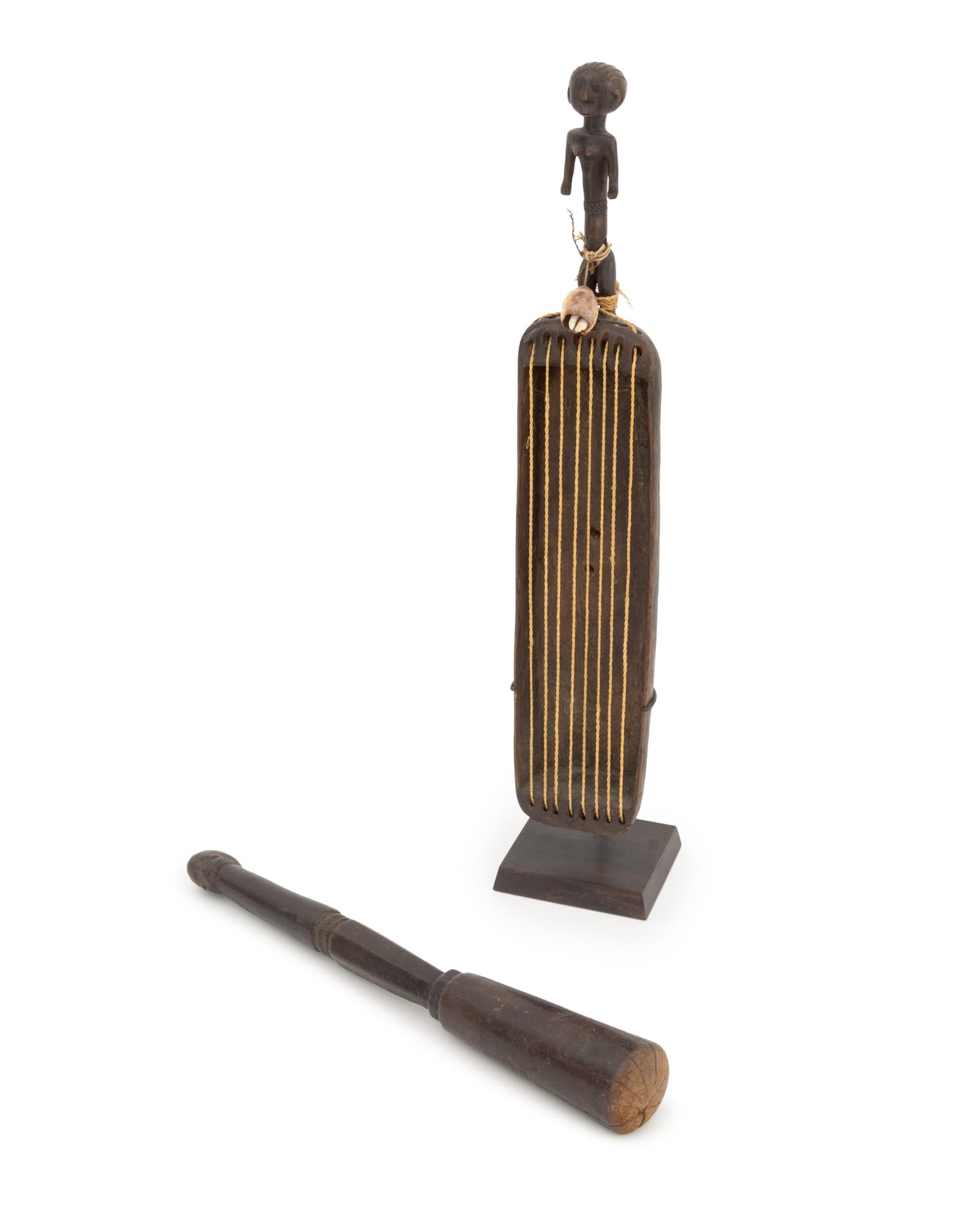 Tanzanian Figural Hand-Carved Wood Instruments, 2: Collection of Two Tanzanian Figural Hand-Carved Wood Instruments, one a harp mounted with cowrie shells to nude female figure form handle and with a fitted stand, together with a wooden pounder or