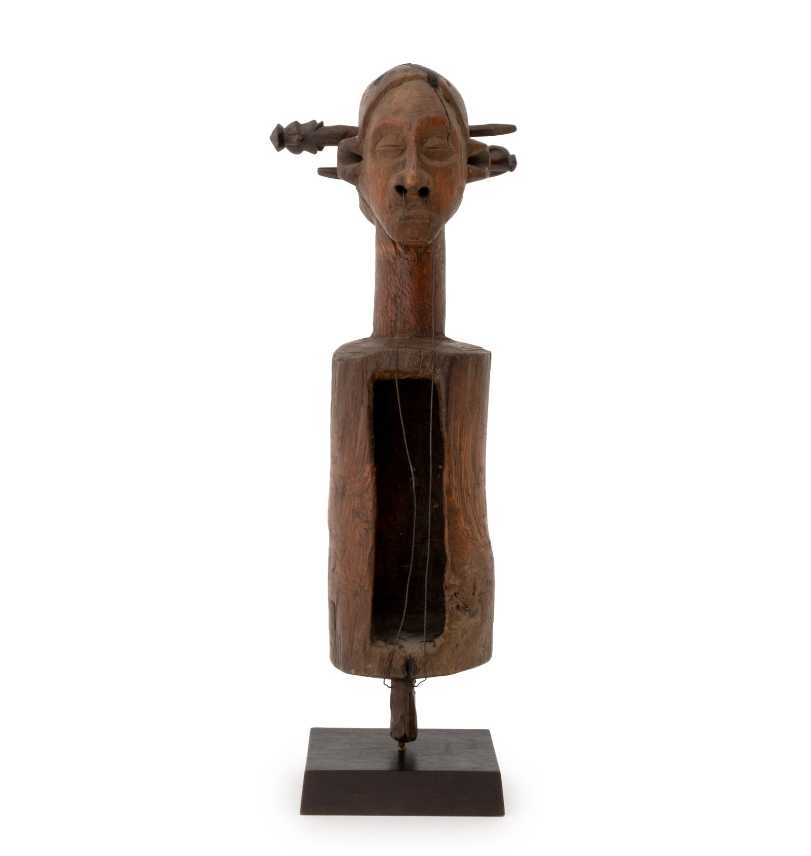 African Suku or Yaka Slit Drum String Instrument: African Suku or Yaka Slit Drum String Instrument, Angola or Democratic Republic of the Congo, hand-carved wood with two wire strings, mounted on an ebonized wood base. Overall: 21" H x 7.5" W x 5.5"