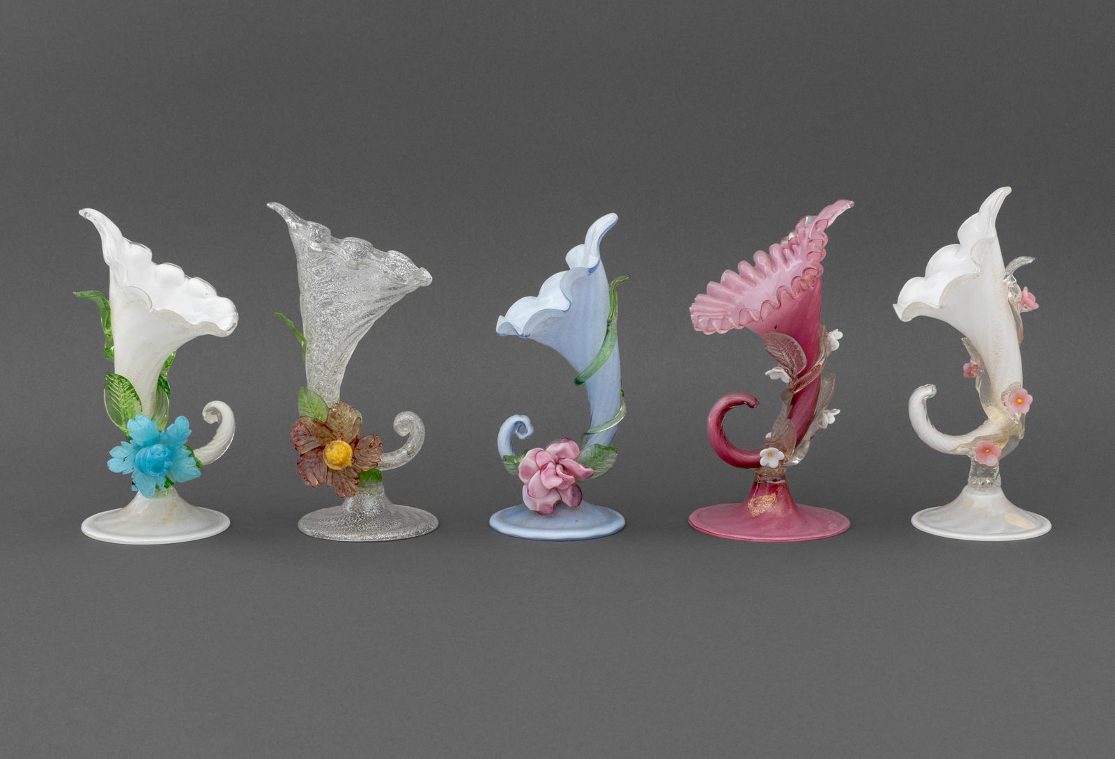 Collection of Murano Glass Cornucopia Vases, 5: Collection of Five Murano Art Glass Cornucopia Vases, two in fluted white gold-flecked glass with applied flowers, one with "Genuine Venetian Glass / F&B Co. / Italy" label, one in clair de lune blue,