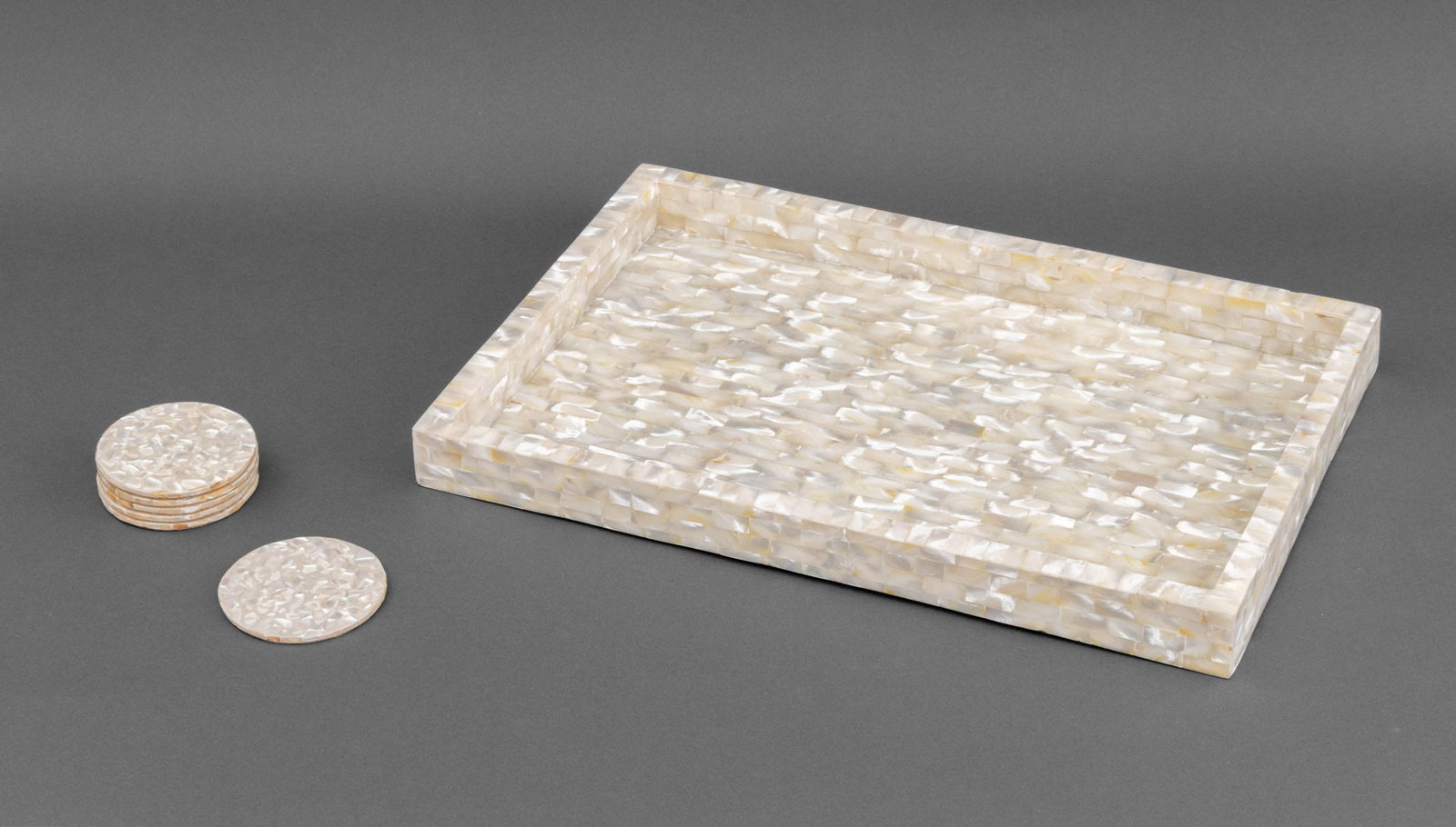 Mother-of-Pearl Cocktail Tray and Coasters, 7 Pcs.: Modern Mother-of-Pearl Cocktail Tray and Set of Six Coasters. Tray: 18" L x 12" W x 1.5" D. Provenance: From a 500 Park Avenue Estate. Keywords: Shell, Nacre, MOP, Tableware, Drinks tray, Serving tray