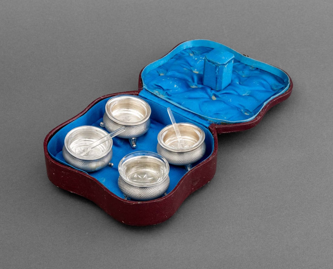 German Art Deco Silver Open Salt Cellars, 4: Set of Four German Art Deco Silver Open Salt Cellars, each circular bowl on three scroll feet with glass liner, and two acrylic salt spoons, struck with "13" hallmark to rim, with fitted leather case.