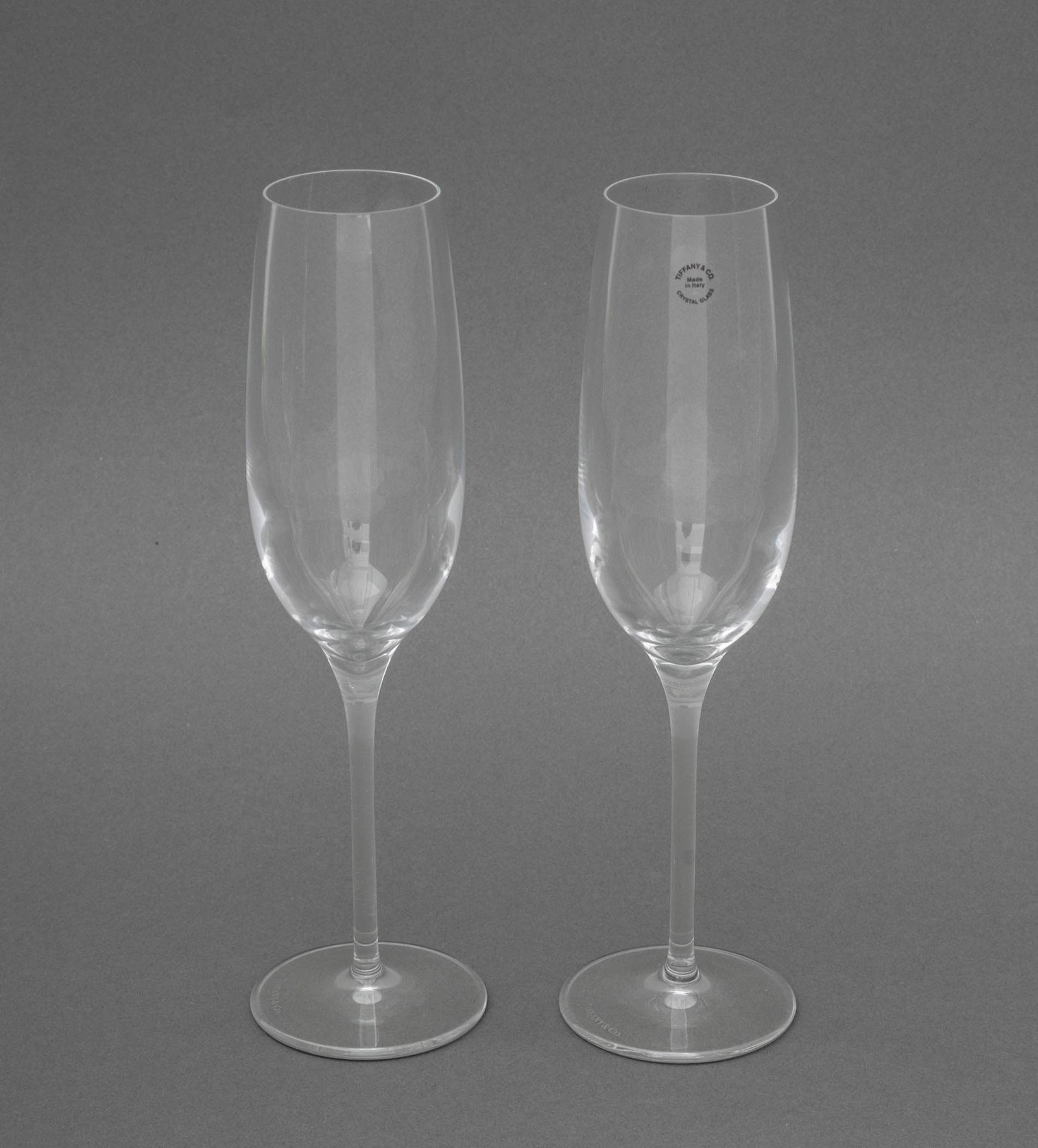 Tiffany & Co. Crystal Champagne Flutes, Pair: Pair of Tiffany and Company Crystal Champagne Flutes, marked "Tiffany & Co." to undersides. 9.75" H x 2.75" Diameter. Provenance: From a Fort Lauderdale, Florida Estate. Keywords: T&Co., Luxury brand,
