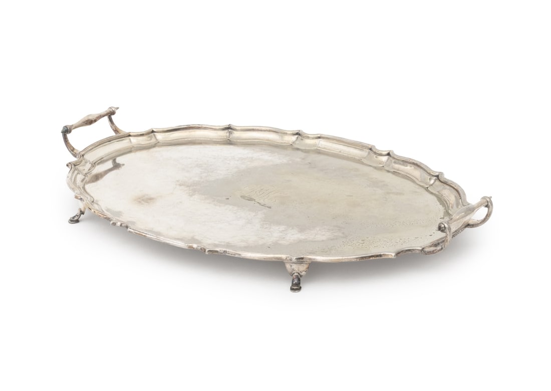 American Silver Plate Two-Handled Serving Tray: American Silver Plate Two-Handled Serving Tray, with scalloped rim on four hoof feet, engraved "RJK", marked "EP / NS / WARRANTED / STRONG PLATE" to underside. 2.75" H x 24" W x 15" D. Provenance: Fro