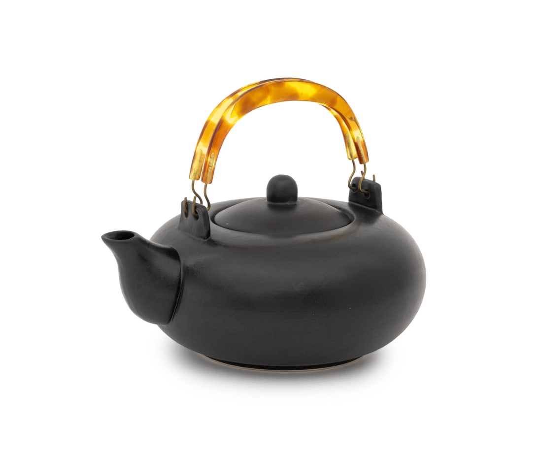 Japanese Black Glazed Ceramic Teapot: Japanese Black Glazed Ceramic Tea Pot, with two faux tortoiseshell handles and fitted silk box. Pot: 3.75" H x 7.75" W x 6.25" D; box: 4.75" H x 9.75" W. Provenance: From a New York City Collection. K