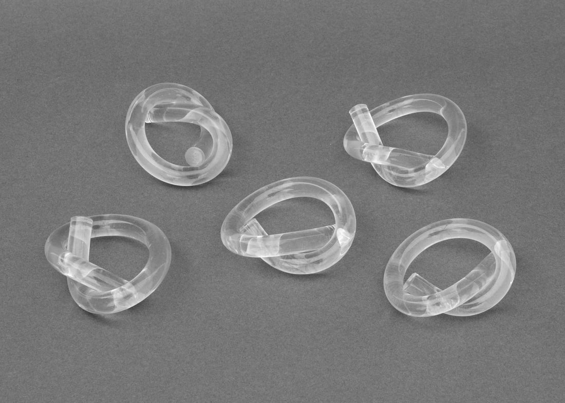 Mid-Century Modern Lucite Pretzel Napkin Rings, 5: Mid-Century Modern Lucite Pretzel Knot Form Napkin Rings, in the style of Dorothy Thorpe. 2.5" H x 3" W x 0.75" D. Provenance: From a Sutton Place Collection. Keywords: Tableware, Place setting, Hosti