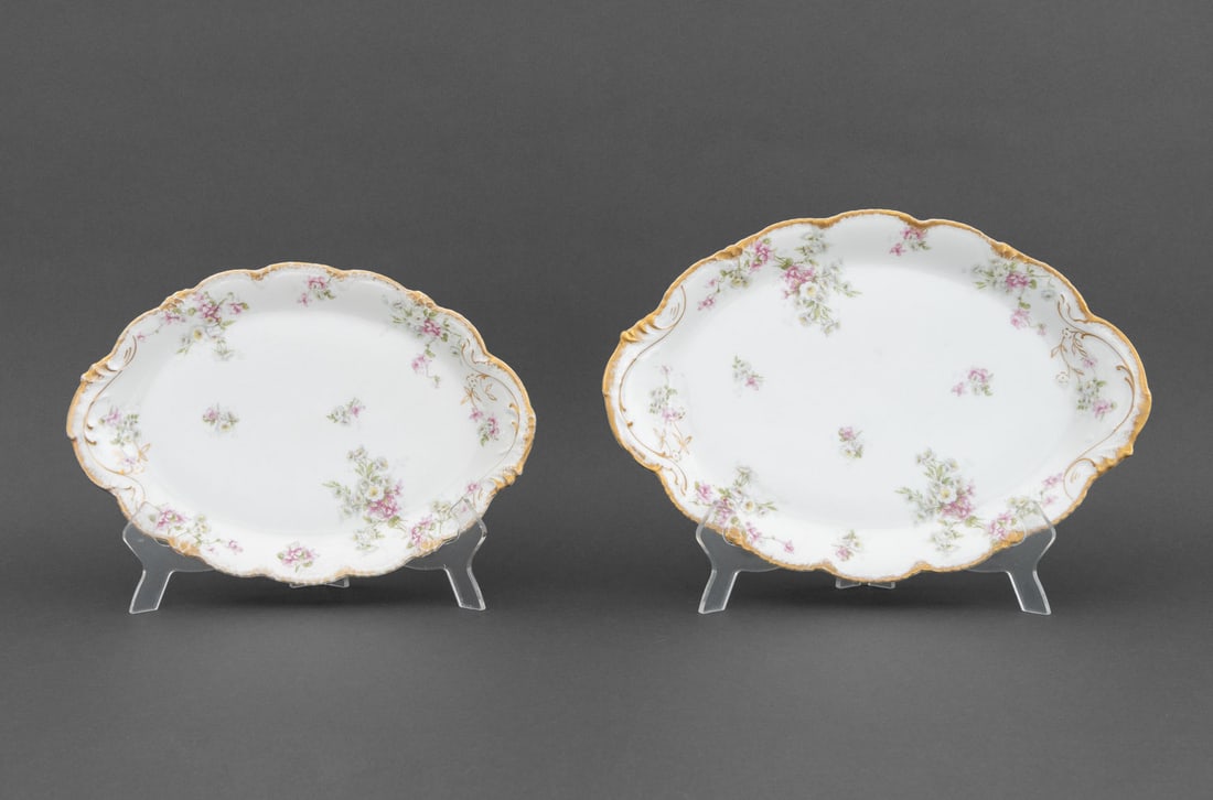 Theodore Haviland Limoges Oval Platters, 2: Two Theodore Haviland Limoges Porcelain Oval Serving Platters, with gilt decorated scalloped rim and pin floral design, marked to undersides. Larger: 2" H x 16.75" W x 11.5" D. Provenance: From the