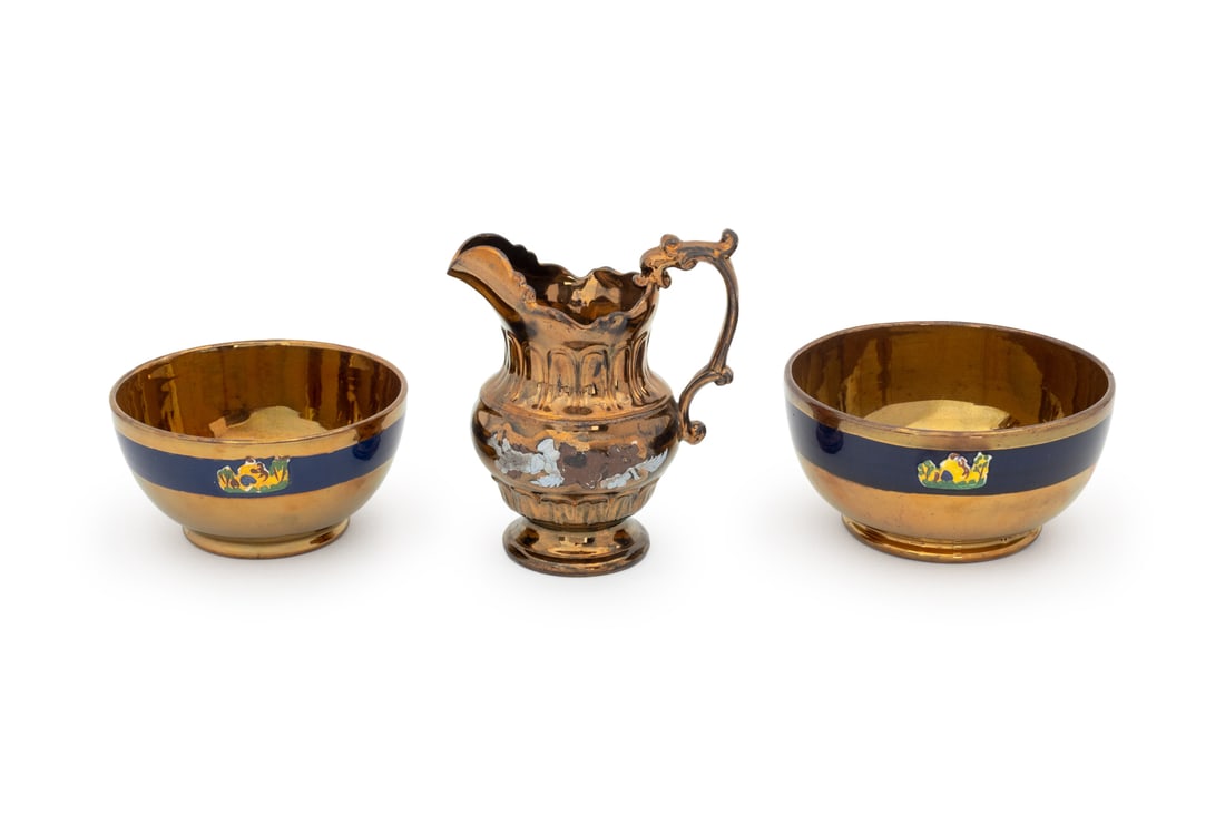 English Copper Lusterware Pitcher & Bowls, 3 Pcs.: English Copper Lustreware Pitcher and Pair of Bowls, the pitcher with blue floral design, the bowls with navy blue band. Pitcher: 7" H x 6" W x 4.5" D. Provenance: From a Tribeca Estate. Keywords: