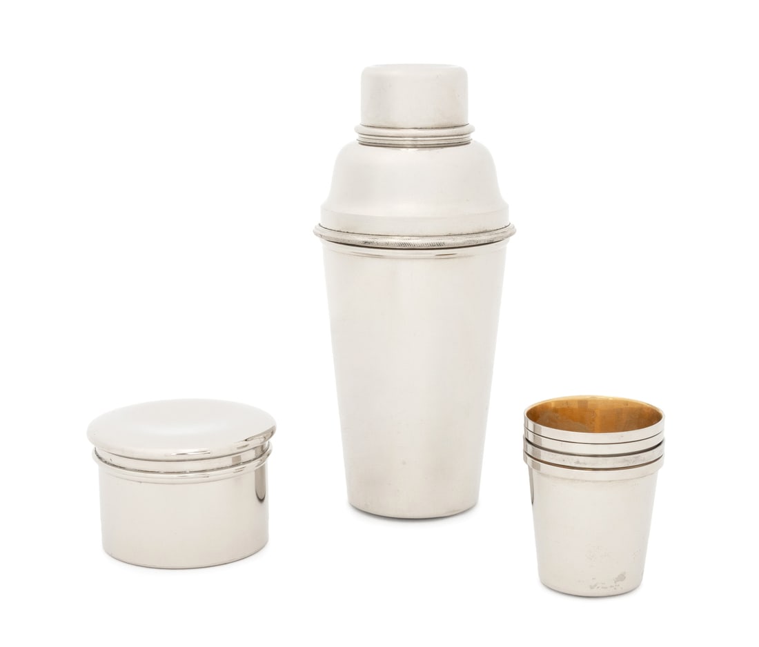 German Chrome Cocktail Shaker Set, 3 Pcs.: German Chrome Three-Piece Cocktail Shaker Set, comprising: shaker, four shot glasses with gold-wash interior, and circular covered jar, with brown leather case, marked "Made in Germany". 7.5" H x