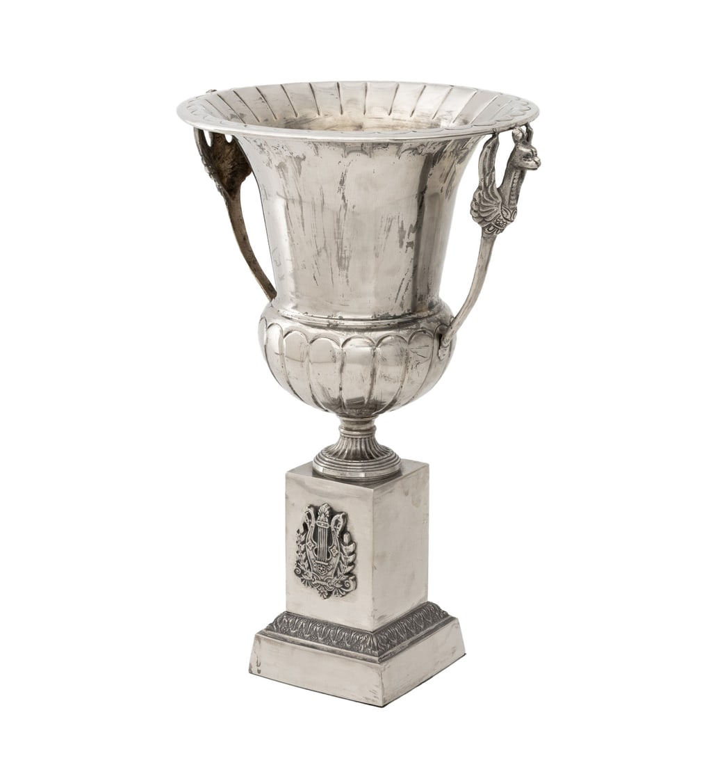 Russian Empire Style Silver Plate Urn Centerpiece: Russian Empire Style Silver Plate Urn Form Centerpiece, with two griffin form handles and raised on a square base with lyre decoration. 19.5" H x 14" W x 12" D. Provenance: From an East Village
