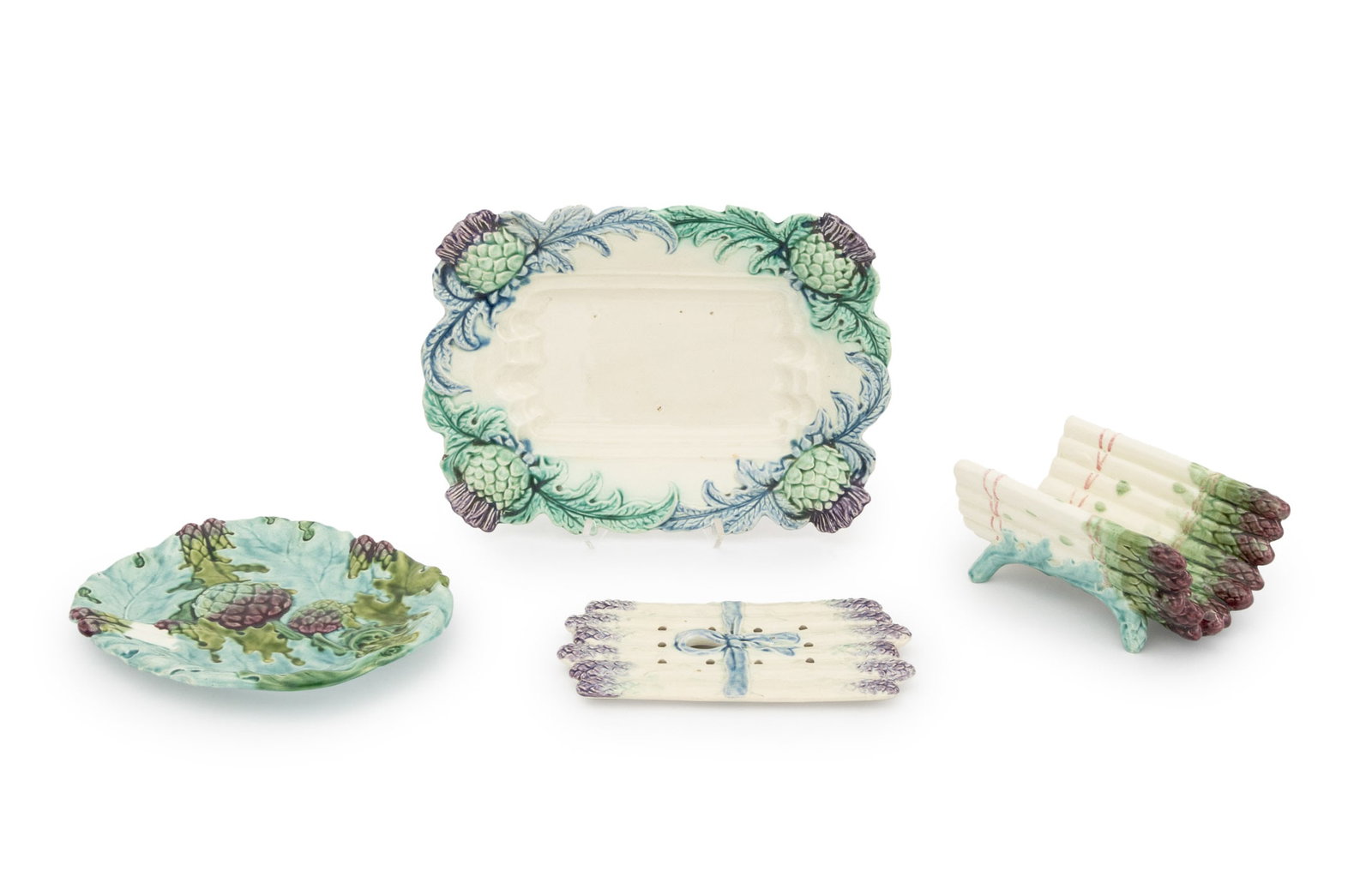 French Majolica Vegetable Serving Trays, 4: Collection of Four French Majolica Vegetable Serving Trays, comprising: two platters with artichoke motif and two asparagus serving dishes. Largest: 2.75" H x 14.25" W x 10.5" D. Provenance: From a Ne