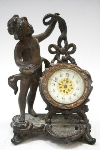 The New Haven Clock Co. Bronze Cherub Desk Clock: A bronze cherub desk clock by The New Haven Clock Company, United States; marked. Dimensions: 6-1/2" H x 4-1/2" L x 3" W