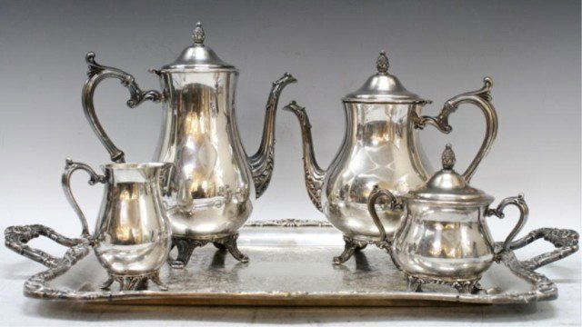 American 5 Pc. Silver William Rogers Tea Set: Five piece William Rogers possibly 900 silver coffee and tea set: tray, coffee pot, tea pot, sugar bowl, and creamer, with pineapple finials and Art Nouveau design, United States; marked. Dimensions: