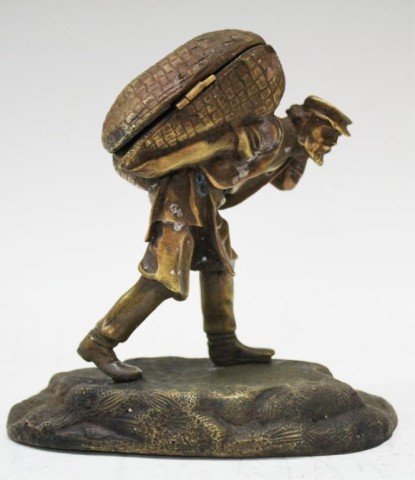 Russian Imperial Bronze Statue Man Carrying Sac: A Russian bronze statue of a man carrying a heavy load in a sac / basket, basket is hinged, possibly used for matches or a candy dish; marked. Dimensions: with stand 6-1/2" H x 6-1/2" L x 3-1/2" W