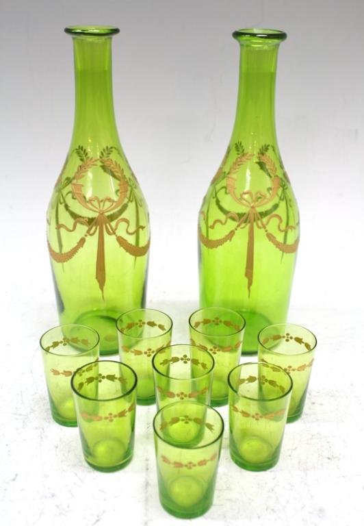 Lot of 10 Baccarat Glass Liquor Set: A baccarat yellow-green glass set with enamel wreath design, two decanters, and eight shot glasses, France; marked. Dimensions: each decanter 8-1/2" H x 2-3/4" diameter; each glass 2-1/8" H x 1-3/8" d