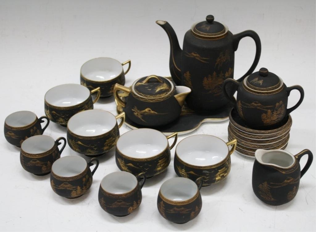 Japanese Coffee & Tea Service w/ Geisha, 21 pieces: A black and gold porcelain coffee and tea set for five with hand painted 22 karat gold landscape designs and geisha portraits on cups that are only visible when held up to the light: six saucers, five
