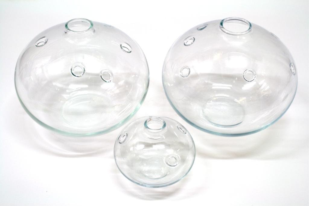 Lot of 3 Holmegaard Glass Bud Vases: Three glass bud vases with cut out hole design, Sweden; signed Holmegaard. Dimensions: larger two 5-1/2" H x 6" diameter; small 3" H x 3-1/2" diameter