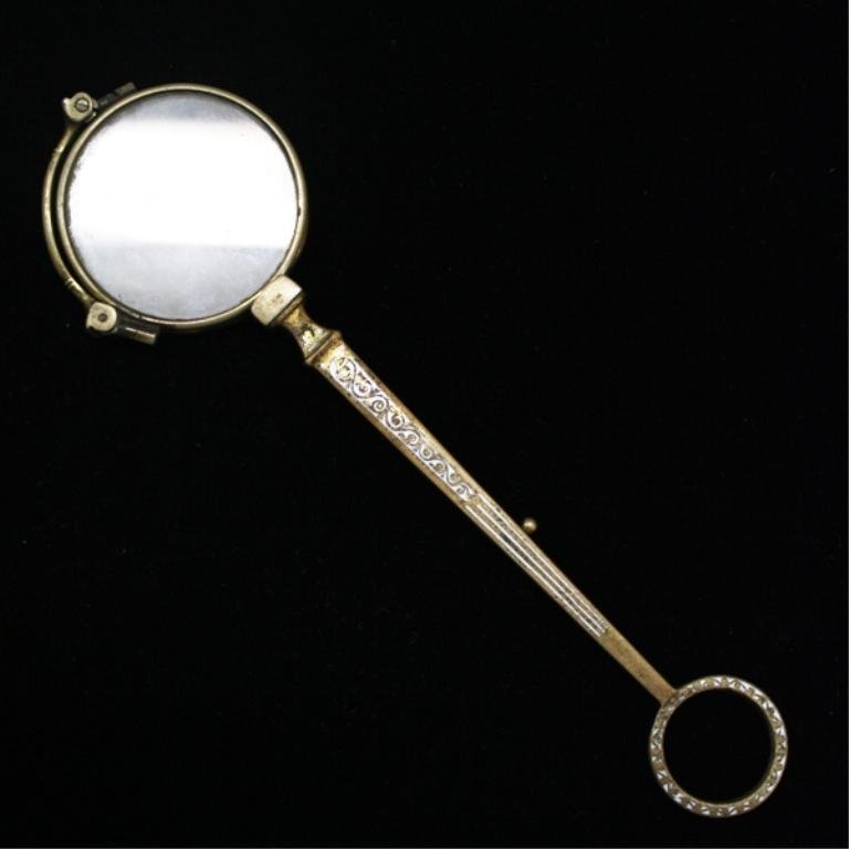 Victorian Double Lens Magnifying Glass: A Victorian magnifying glass with two lenses that fold out when slightly assisted by hand and a switch is pulled, second lens doubles magnification; unmarked. Dimensions: 6" L