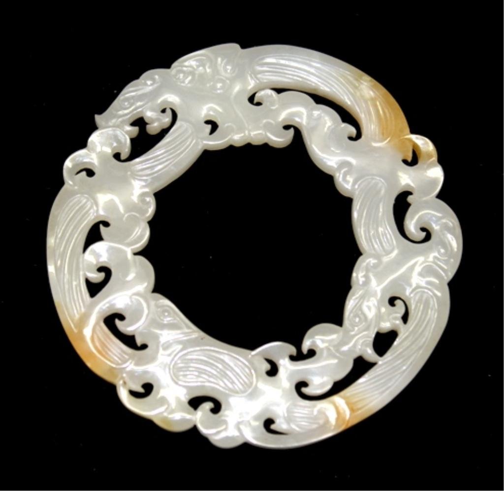 Chinese Openwork White Jade Bi-Disk w/ Dragons: A white jade bi-disk with openwork carving of dragons and natural orange spots, China; unmarked. Dimensions: 3-1/4" diameter