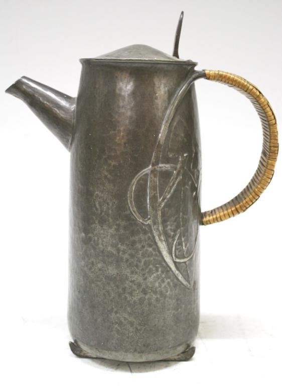 English Archibald Knox Pewter & Wicker Teapot: An art nouveau, Archibald Knox pewter teapot with wicker handle, England; marked. Dimensions: approximately 8-3/4" H x 7-1/2" L (spout to handle) x 3-1/2" diameter
