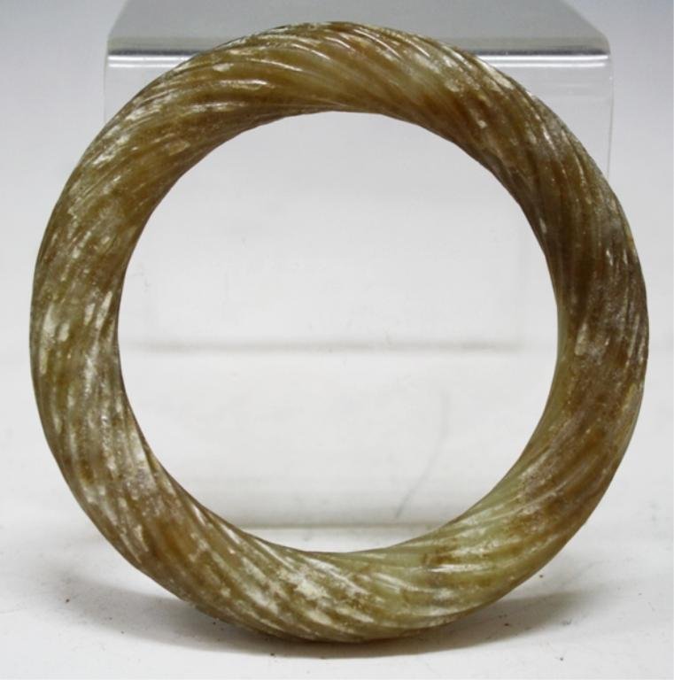 Chinese Jade Carved Bangle, poss. Han: A jade bangle carved with swirling design, China, possibly Han Dynasty (206 B.C. - 220 A.D.); unmarked. Dimensions: approximately 1/2" thick, 3-1/2" diameter