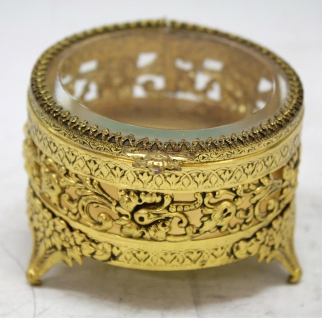 Brass & Crystal Filigree Jewelry Box: A brass and crystal jewelry box with filigree floral motif; unmarked. Dimensions: approximately 2-1/4" H x 3-1/4" diameter