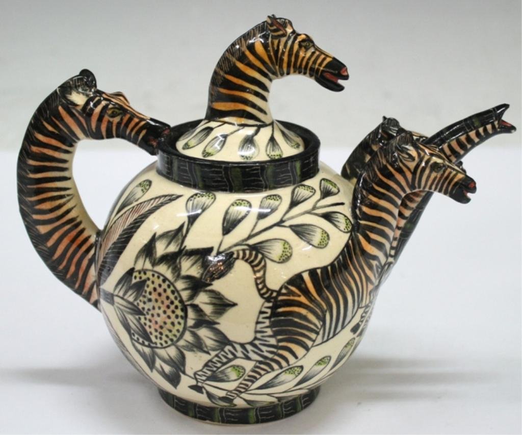 Ardmore "Zebra Teapot," South African Ceramic Art: A unique ceramic teapot combining a wheel-thrown body with hand-built miniature zebras that form the spout, lid and handle. The teapot, hand-painted to unify the body with the zebras, was produced by 