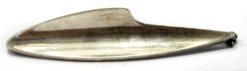 Bent Knudsen Danish Modern Sterling Brooch: Sterling silver, ca. 1960s, being pattern no. 2 by the Danish mid-century silversmith Bent Knudsen, a plaque in the form of an elongated oval gnomon, marked on reverse "Sterling Denmark Bent K 2." 2.7
