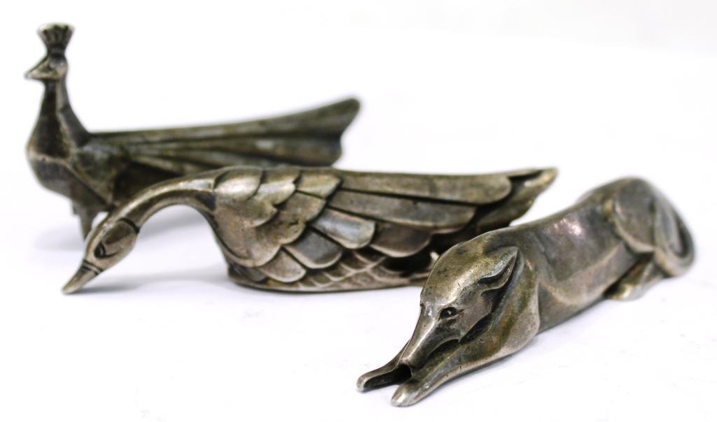 3 Christofle Gallia Art Deco Animal Knife Rests: France, ca. 1920s, a swan, peacock and hound stylized and elongated into knife rests, each marked "O. Gallia" for Christofle's Gallia metal, a very strong pewter-like alloy that formed many of its pie