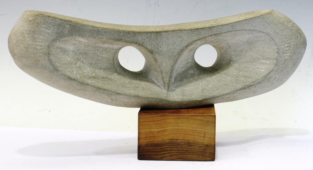 Don Burrows (American, 20th C.)- Owl Sculpture: The dual-sided minimalist stone piece of long, narrow form, one half carved with an owl face, the lower right edge with the artist's monogram of a curving "B," the other with random all-over crosshatc
