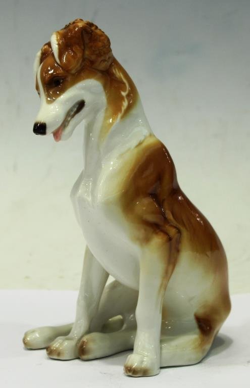 Nymphenburg Porcelain Dog, by Theodore Kaerner: Depicted seated asprawl with two legs to one side, impressed with the shield mark of Nymphenburg, Germany, and the artist's name "T. Kaerner" on the underside. 7.75" H.