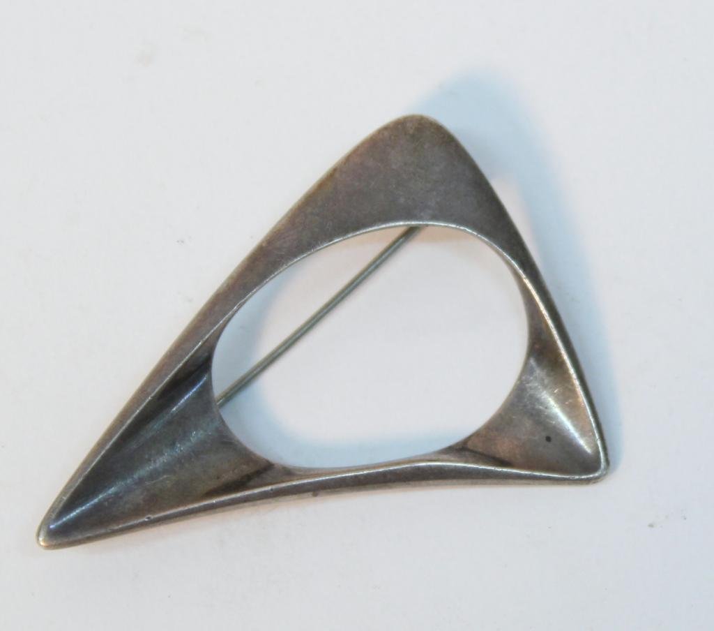 Georg Jensen Sterling Open Triangle Brooch #375: Designed by Henning Koppel ca. 1950, the silver back stamped "Georg Jensen / Sterling / 375," with the 1945 - present mark. 1.5" H X 2.25" W. Weight approximately 0.50 troy ounces.