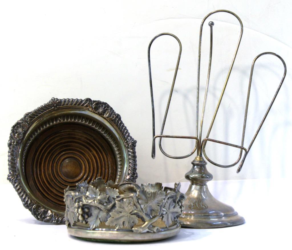 3 Antique Silver-Plate Items: Comprising a cookbook holder, monogrammed "JAA," the base stamped "Wilcox S.P. Co. / Pat'd. Mar 25, 1913," and two English wine coasters, the first a high-relief openwork design of grape leaves and cl