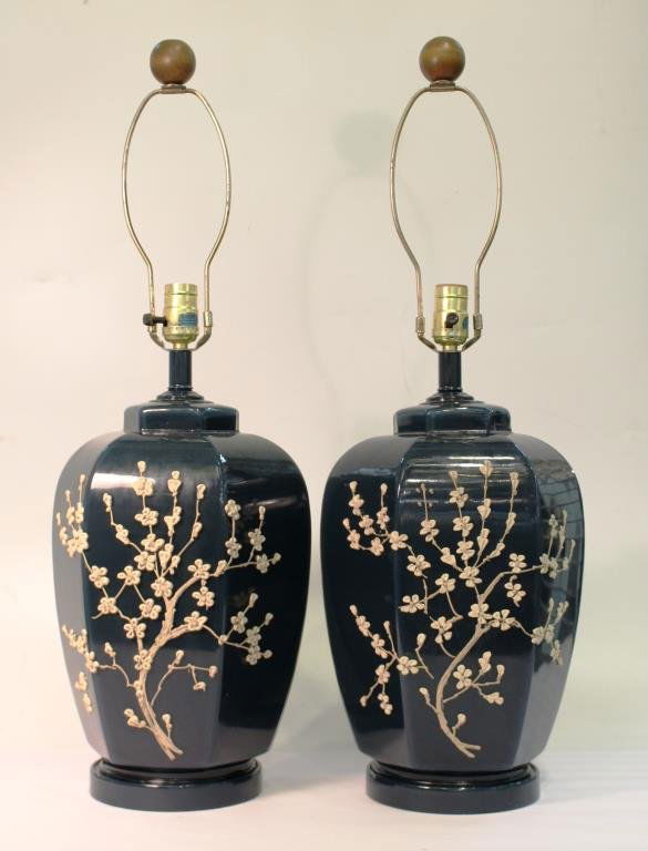 Pair of Hand-Blown Glass Table Lamps: The hexagonal teal bodies with hand-applied sprays of delicate porcelain cherry blossoms. Overall with harps: 29" H.