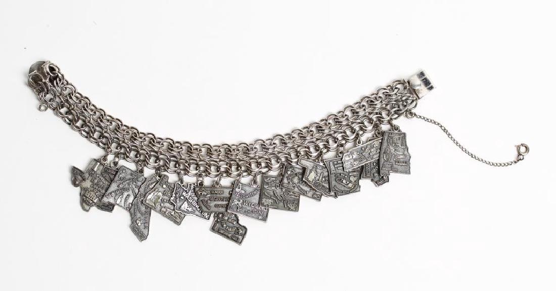 Jacoby Bender Sterling Silver 16-Charm Bracelet: Depicting various states in the Union, the clasp of the sextuple-link bracelet stamped "Sterling," with "JB" in a pyramid. Interior: 2.25" diameter. Approx. 2 ozt.
