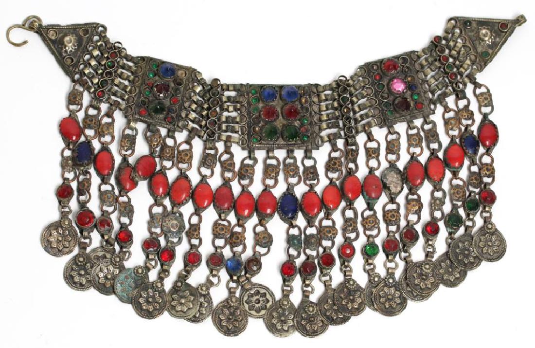 North African Tribal Choker Necklace: Metal with red, blue and green glass decoration having dangle coin metals with repousse rosettes. 13" L. Property from the estate of the renowned belly dancer Serena Wilson.