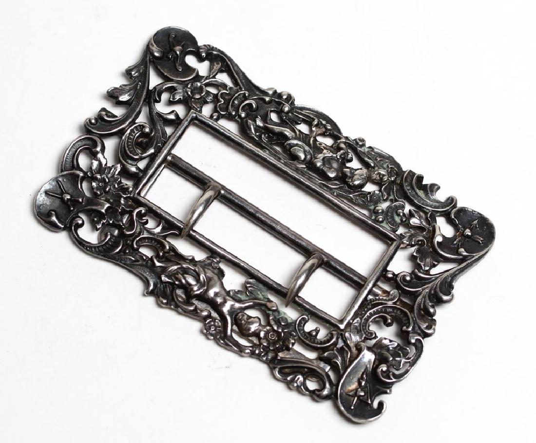 Gorham Silver Belt Buckle: Of rectangular form with decoration of Cupid, hearts and arrows within a pierced C-scroll and floral border, marked on reverse with hallmarks and "Sterling." 2.25" H X 3.25" W. Approx. 1.35 ozt.