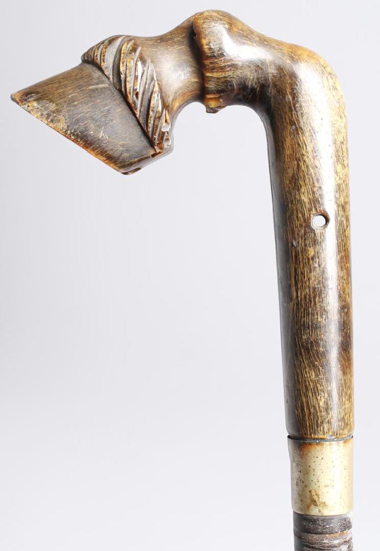 Antique Walking Stick with Horse Hoof Handle: Probably English, the well-carved wood handle in the form of a horse's hoof and fetlock mounted on a leather-wrapped stick. 34" L. Small old chip to hoof edge, drilled with hole for hanging thong.
