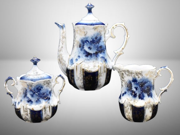 Handpainted porcelain 3 pc. cobalt dematisse tea set, lots of gold highlights: Handpainted porcelain 3 pc. cobalt dematisse tea set, lots of gold highlights; 6.5"h pot, 4" creamer and 4.5" cov. sugar