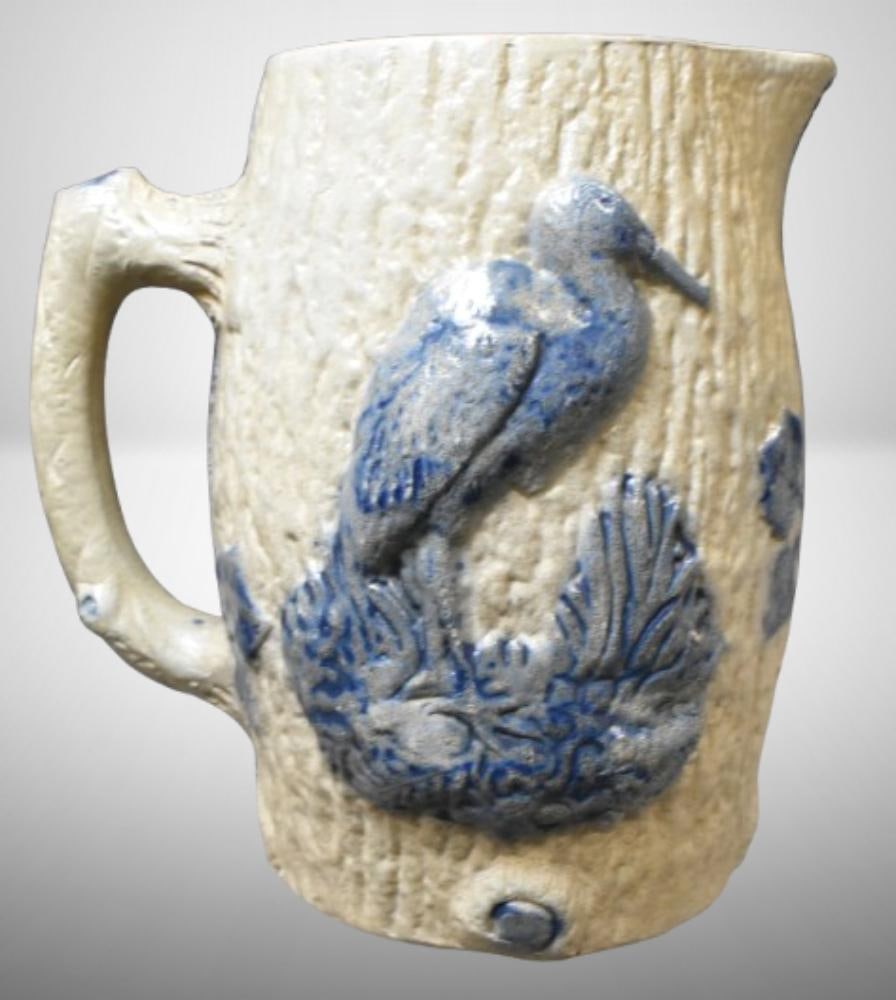 White's Utica blue Flenish stoneware 7.5"h pitcher w/ crane and rose decoration; . Please use: White's Utica blue Flenish stoneware 7.5"h pitcher w/ crane and rose decoration; . Please use pictures as part of the description. Brown Auction attempts to call any flaw that can affect the value of