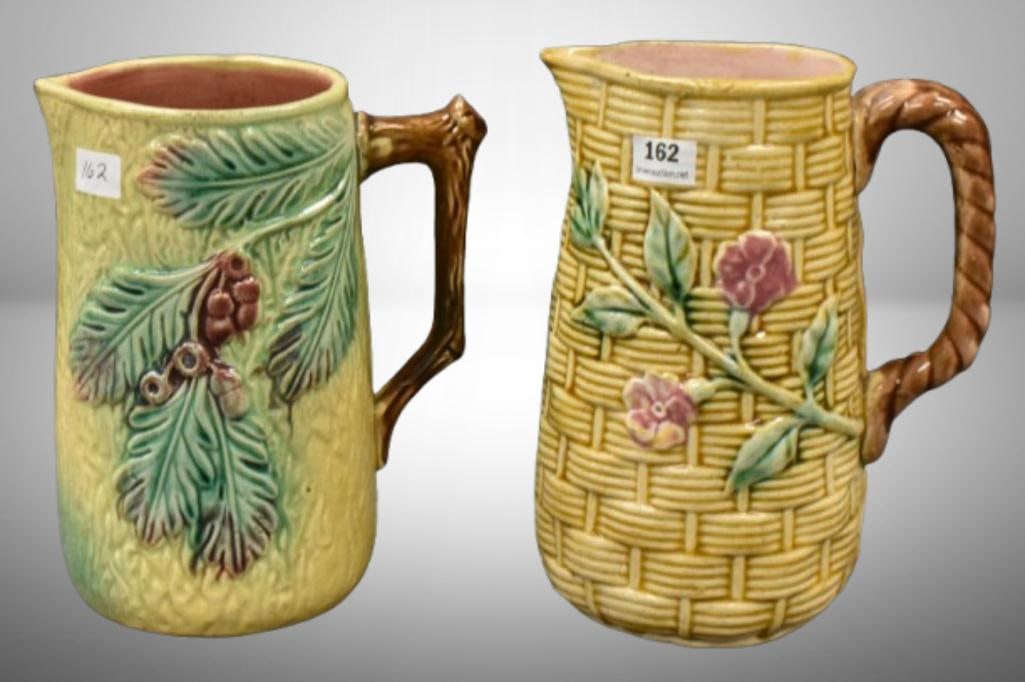 (2) Majolica pitchers, 6.5" and 7" heights; 1-Basketweave w/ flowers design; 1-leaves and berries.: (2) Majolica pitchers, 6.5" and 7" heights; 1-Basketweave w/ flowers design; 1-leaves and berries. Please use pictures as part of the description. Brown Auction attempts to call any flaw that can affe
